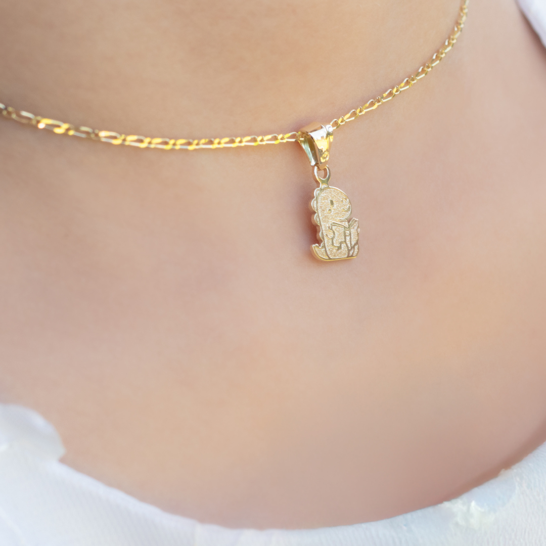 Gold necklace with a pendant on a plain background