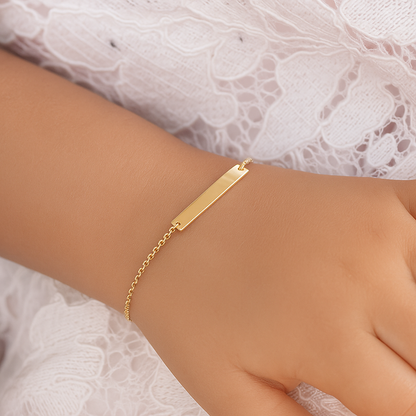 14 K Gold bracelet on a wrist with a white lace background